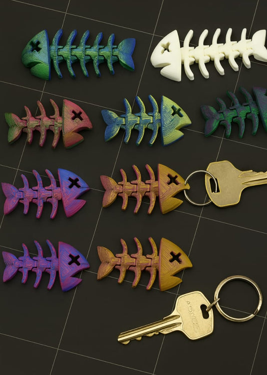 Colorful articulated fish skeleton keychains arranged on a black tiled surface