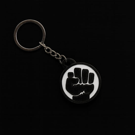 Keychain with a black fist symbol on a white background against a black background